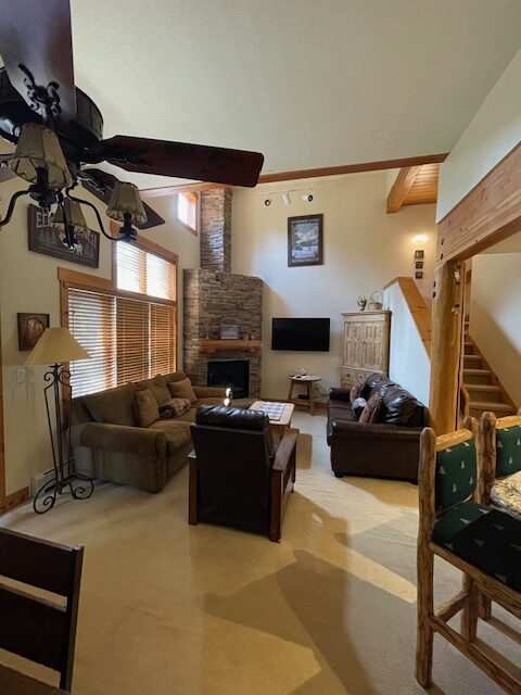 A living room with couches, chairs and a fireplace.