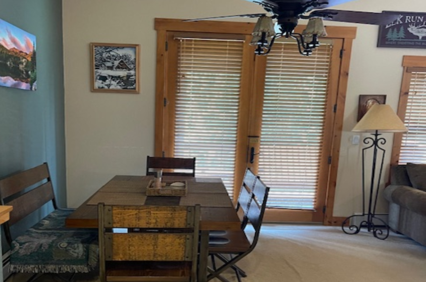 A dining room table with chairs and a ceiling fan.